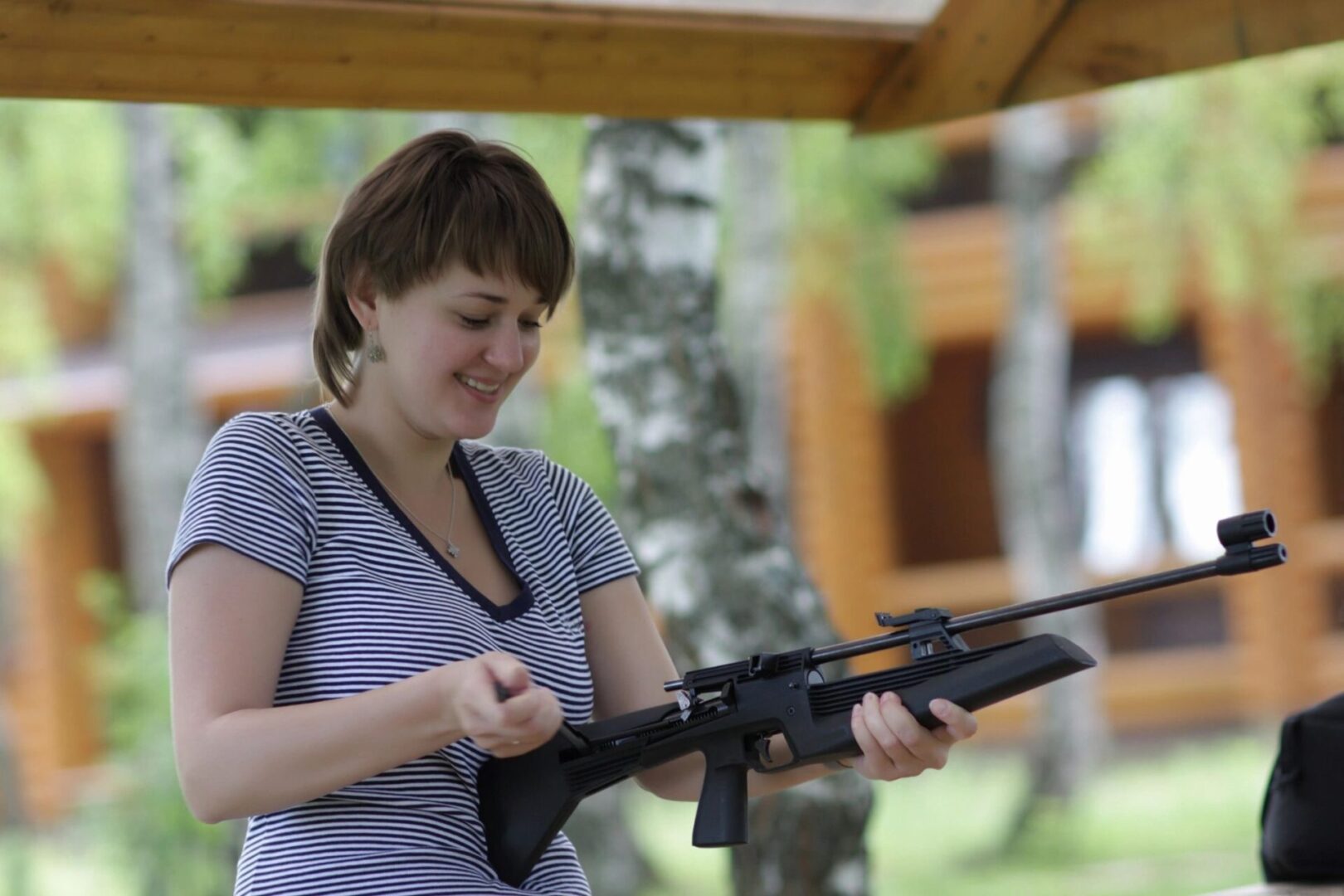 A woman holding an ar-1 5 rifle in her hands.